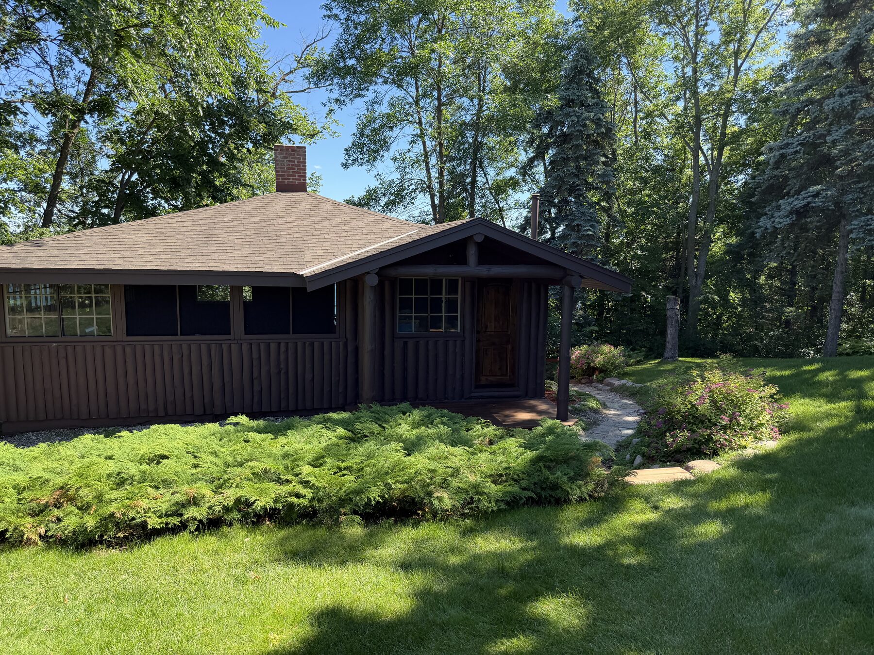 Front exterior of the log cottage, tucked among the pines